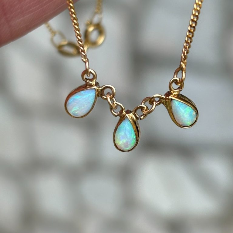 Gold necklace with three teardrop-shaped flashy Australian opal pendants.